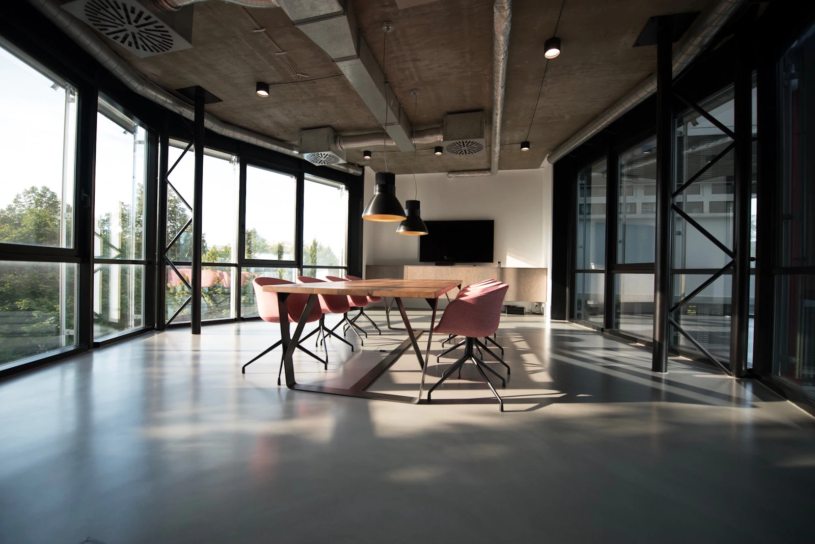Sunlit meeting room with a long table and glass walls